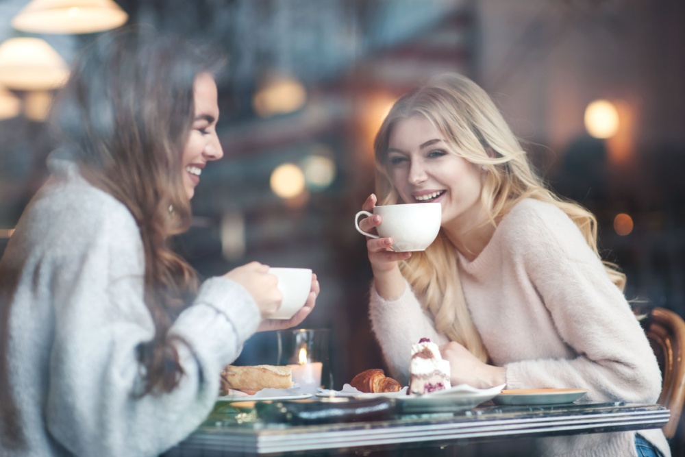 Two women talking and drinking coffee.