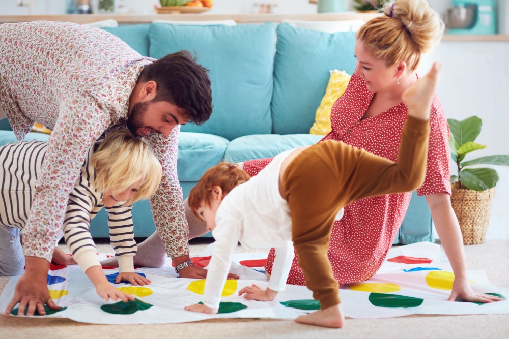 A family with young children playing Twister.