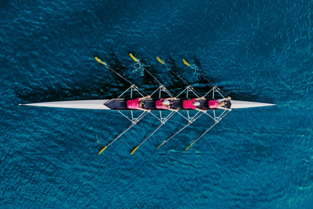 A bird’s eye view of a rowing team on the water.