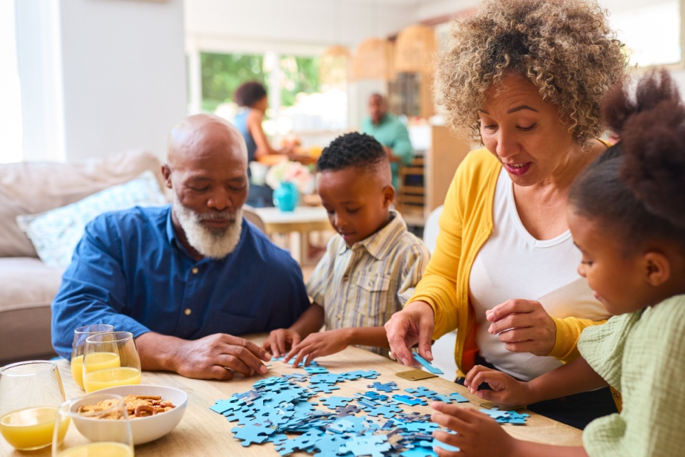 Grandparents doing a jigsaw with their two grandchildren.