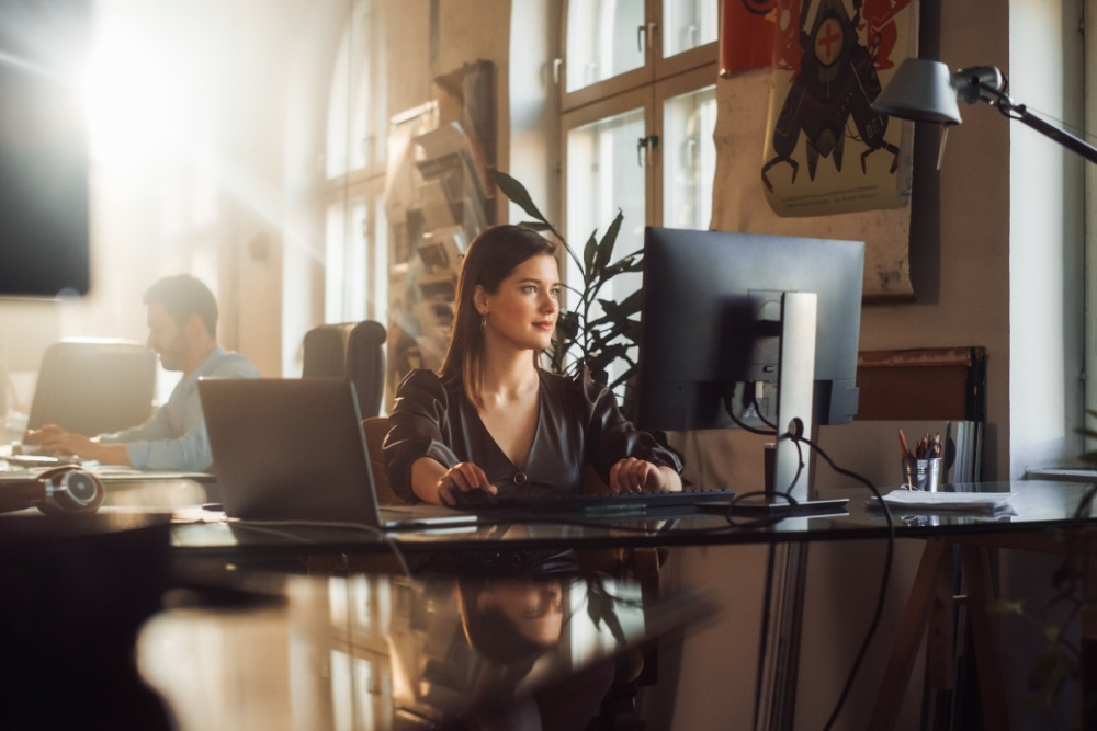 A woman using a computer in an office.